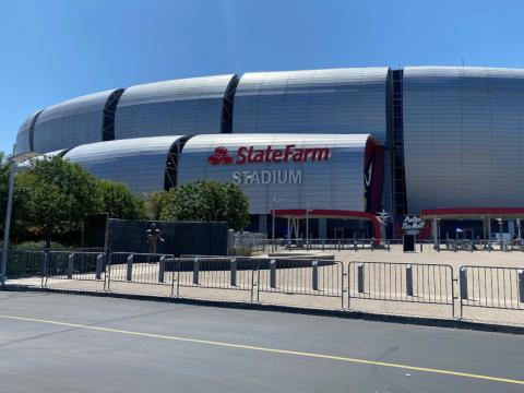 La fachada del State Farm Stadium tiene un revestimiento de paneles metálicos que parecen espejos y reflejan los rayos del sol.