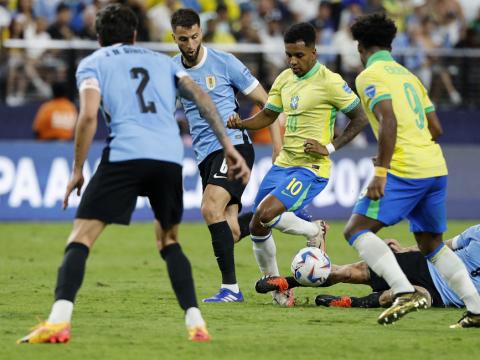 Momento exacto en el que Nahitan Nández se barre por detrás de Rodrygo para impactar su tobillo durante el partido ante Brasil.