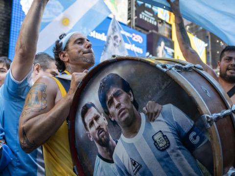 Aficionados de la selección argentina de fútbol animan al equipo durante un 'banderazo' en la plaza de Times Square, este lunes en Nueva York (Estados Unidos).