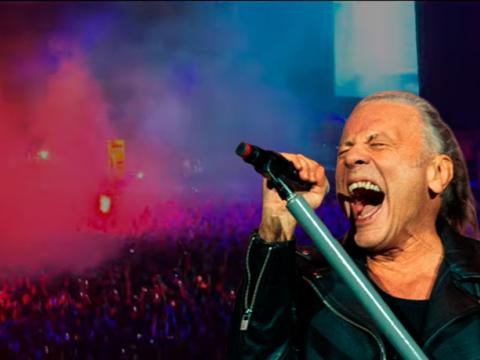 Composición que muestra al vocalista de Iron Maiden, Bruce Dickinson, y las bengalas que se prendieron en el concierto en Quito, el 14 de octubre de 2026.