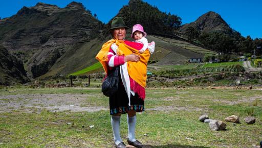 Mujer indígena ecuatoriana cargando a un bebé.