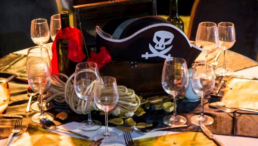 Mesa de fiesta en la playa con decoración de piratas.