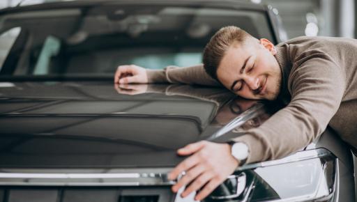 Hombre abrazando su auto.