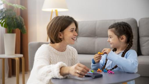 Madre jugando con su hija en la sala de su hogar