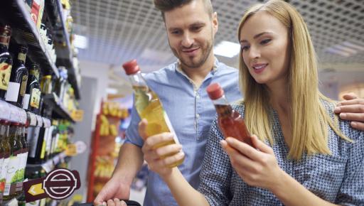 Hombre y mujer comparando precios de productos en supermercado