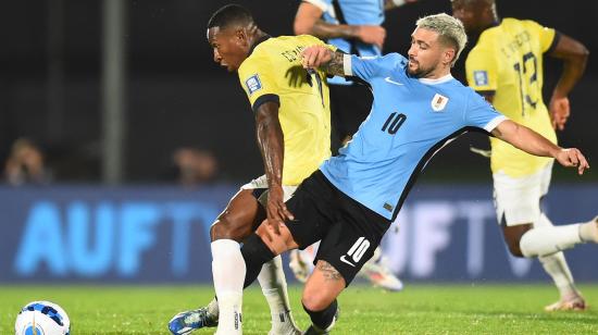 Pervis Estupiñán disputa una pelota con Giorgian de Arrascaeta, en el partido entre Ecuador y Uruguay, el 15 de octubre de 2024.