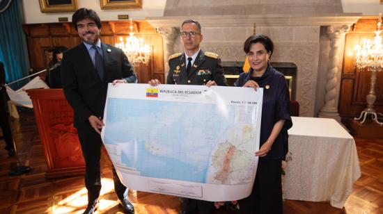 El Ministro de Gobierno, José de la Gasca, el director de Instituto Geográfico Militar, Crnl. Iván Ramírez, y la canciller de Ecuador, Gabriela Sommerfeld, sostienen una versión impresa del nuevo mapa físico de Ecuador, el 17 de diciembre de 2024.