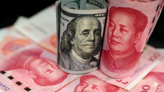 Fotografía hecha en abril de 2025 que muestra un billete de 100 dólares estadounidenses junto a un billete de 100 yuanes chinos.