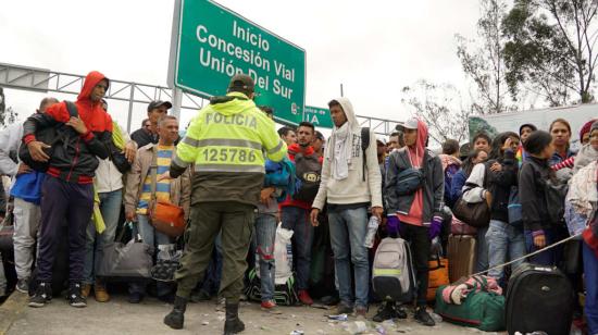 Un grupo de ciudadanos venezolanos espera en el punte internacional de Rumichaca para ingresar a Ecuador y luego avanzar hasta Perú.