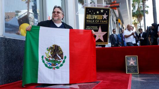 Guillermo Del Toro sostiene una bandera de su país en la ceremonia en la que recibió una estrella en el Paseo de Hollywood.