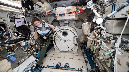 Anne McClain, astronauta de la Estación Espacial Internacional, durante una revisión de rutina de uno de los robots a bordo de la nave en abril de 2019.