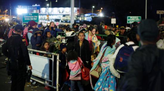 Ciudadanos venezolanos esperan para cruzar la frontera entre Colombia y Ecuador, la noche del domingo 25 de agosto de 2019.