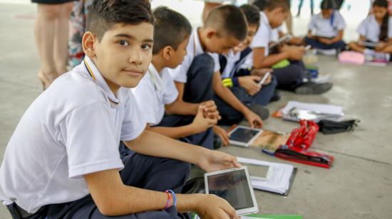 Imagen de archivo de agosto de 2019 de los niños de la Unidad Educativa República del Ecuador, en la ciudad de Manta, usando dispositivos electrónicos.