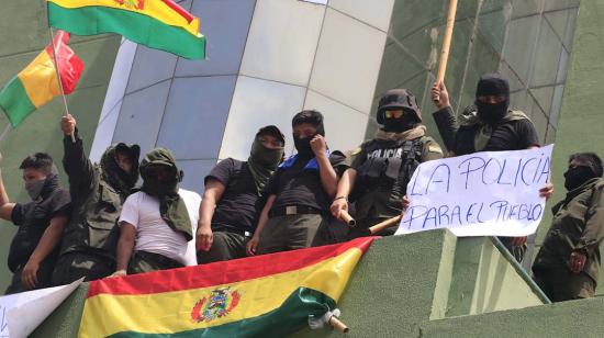 Un grupo de policías ondea la bandera tricolor de Bolivia en la azotea de una comisaría este sábado en la ciudad de Santa Cruz (Bolivia)