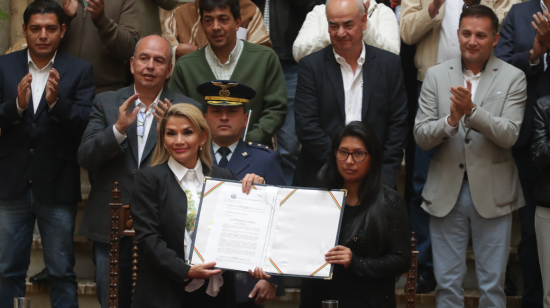 La presidenta interina de Bolivia, Jeanine Áñez y la titular de la Cámara de Senadores, Eva Copa, sostienen la ley que convoca a nuevas elecciones en el país andino. 