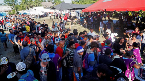 En el municipio guatemalteco de Tecún Umán, fronterizo con México, migrantes hace fila para recibir alimentos.