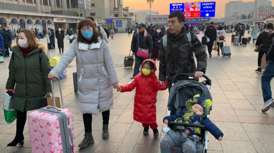 En Pekín, las personas que van a viajar para celebrar el nuevo año chino utilizan mascarillas.