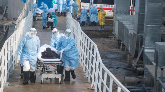 Trabajadores del sector de salud de China llevan al primer paciente con coronavirus al recientemente construido hospital de Huoshenshan, en Wuhan.