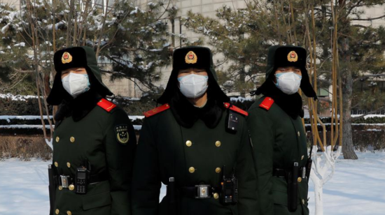 Tres policías chinas, protegidos con mascarillas, custodian la entrada del Banco Popular (Banco Central) de ese país.