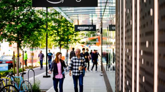 Fotografía cedida por Amazon donde aparecen dos personas mientras caminan frente a la primera tienda de Amazon Go en Seattle, Washington.