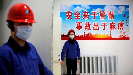 Trabajadores que llevan máscaras protectoras durante una gira organizada por el gobierno en Beijing Huadian Bjgas Energy Co, en  Beijing, China, 27 de febrero de 2020.