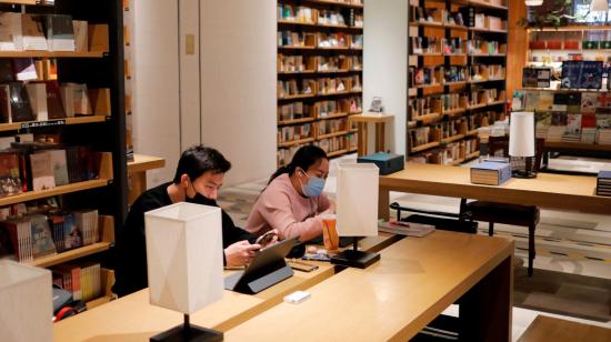 Las personas que llevan máscaras protectoras se sientan en una librería en un centro comercial en Beijing, China, 28 de febrero de 2020. 