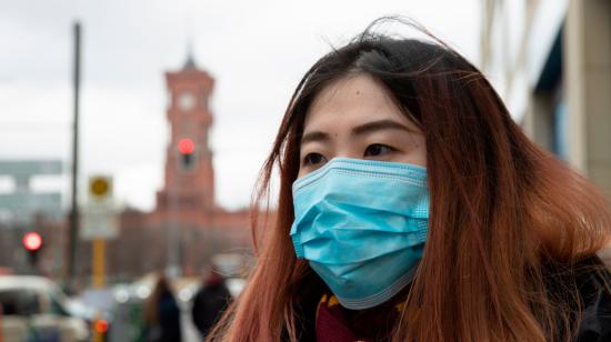 Un turista de China lleva una máscara facial médica mientras hace turismo en Berlín, Alemania, 28 de febrero de 2020. 