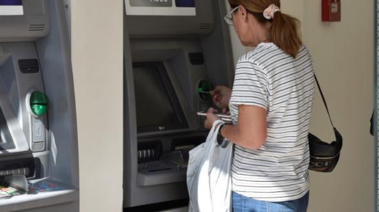 Imagen referencial de una ciudadana haciendo un retiro de un cajero automático de un banco en Quito en 2019.