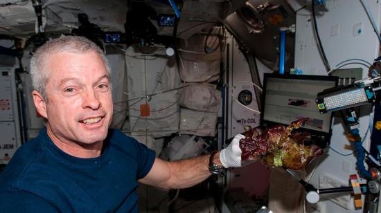 El astronauta de la NASA Steve Swanson con una de las lechugas cultivadas en la ISS. 