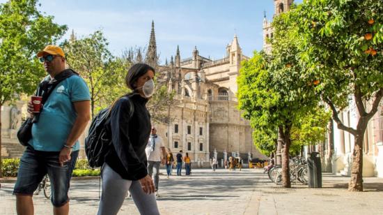 Turistas recorren con mascarilla las calles céntricas de Sevilla con motivo de la crisis del coronavirus.