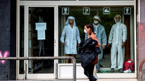 Una mujer camina frente a un local cerrado en Italia, el 17 de marzo. 