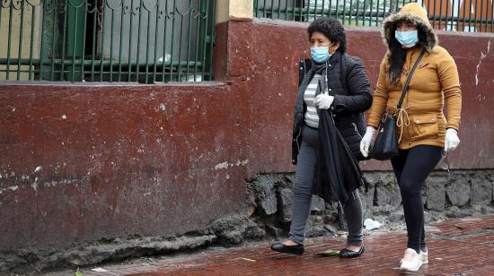 Ciudadanas con mascarillas caminan al Mercado de San Roque en el Centro Histórico de Quito, 17 de marzo de 2020.