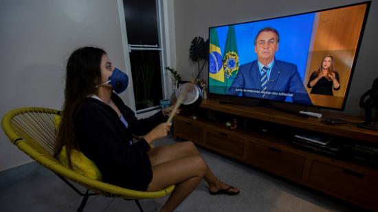 Una mujer con una máscara protesta golpeando una olla, durante una declaración de Bolsonaro, este 24 de marzo.