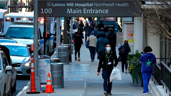 Persona caminando con mascarillas por la entrada del Hospital Lenox Hill en Nueva York, el 26 de marzo.