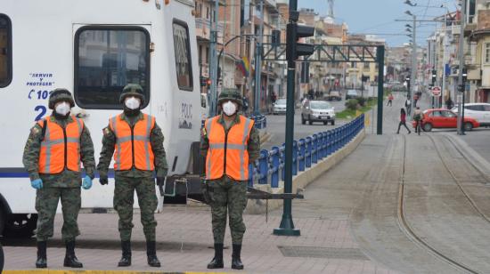 En el sector de la Chola, en Cuenca, uniformados controlan el movimiento vehicular antes del toque de queda, el 30 de marzo.