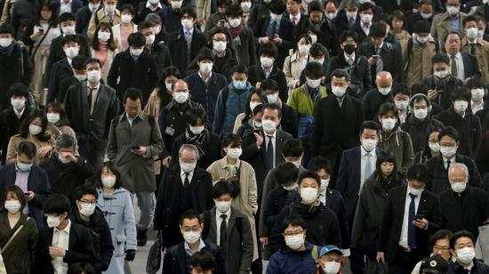 Personas en una estación de tren, en Tokio, se dirigen a sus trabajos este martes 31 de marzo.