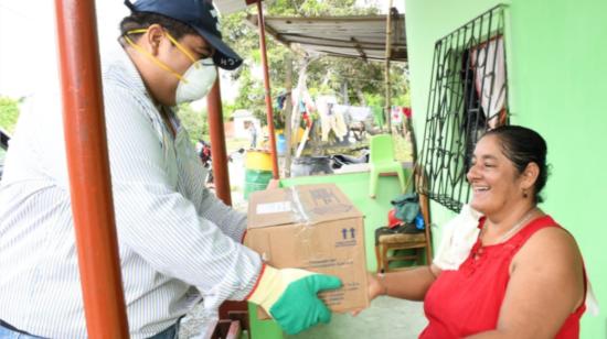 Una mujer recibe víveres durante la emergencia sanitaria, a través de la campaña Unidos Somos Más, coordinada por Karla Morales. 