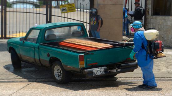 Un trabajador fumiga un féretro antes de ingresar a un cementerio en Guayaquil, el 1 de abril. 