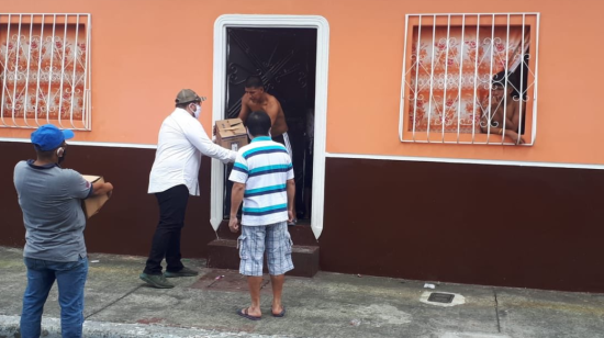 Funcionarios del Municipio de Guayaquil entregan kits de alimentos en casas del suburbio de la ciudad.