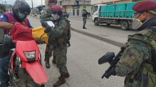 Militares piden documentación a un motociclista en uno de los puntos de control establecidos en Guayaquil, el 3 de abril. 