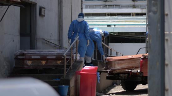 Trabajadores del hospital Teodoro Maldonado Carbo Hospital, en Guayaquil, cargan los ataúdes de dos personas fallecidas por coronavirus, el 3 de abril de 2020.