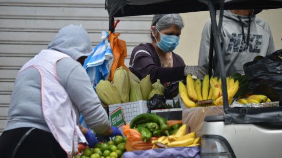 Personas comprando frutas en una camioneta en Cuenca, el 5 de abril. 