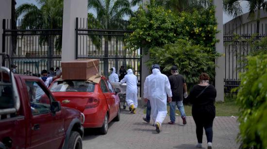 Vehículos cargan ataúdes en los exteriores del cementerio Parque de la Paz en Durán, el 13 de abril de 2020.