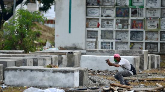 Un hombre mira una tumba en el cementerio Ángel María Canales, en Guayaquil, el 15 de abril de 2020.