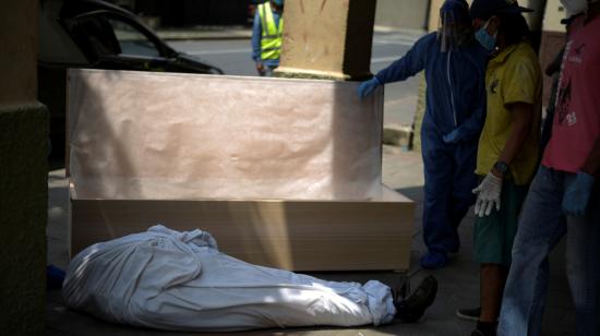 Empleados de una funeraria y miembros de la familia de una persona fallecida en su casa preparan el ataúd para su traslado, el 17 de abril de 2020 en Guayaquil. 