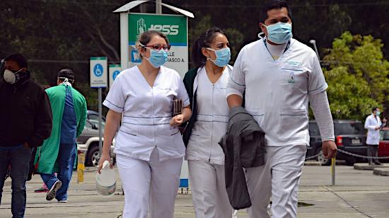 Tres trabajadores de la salud caminan afuera del Hospital José Carrasco Arteaga, en Cuenca, el 30 de abril de 2020.