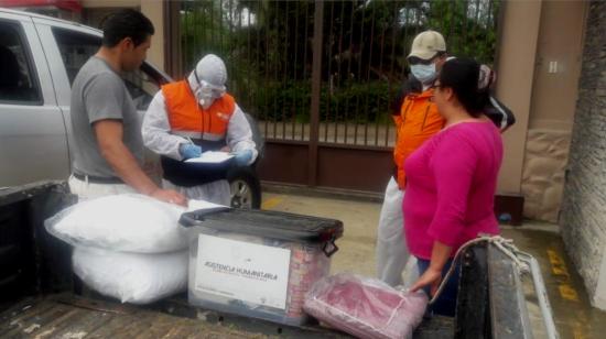 La Secretaría de Riesgos entrega asistencia humanitaria en El Descanso (Azuay), el 3 de mayo. En la imagen se ve el kit alimenticio de USD 150,82, en el contenedor de tapa negra.