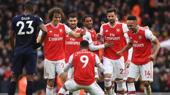 Los jugadores del Arsenal festejan un gol en grupo, en un partido por la Premier League.