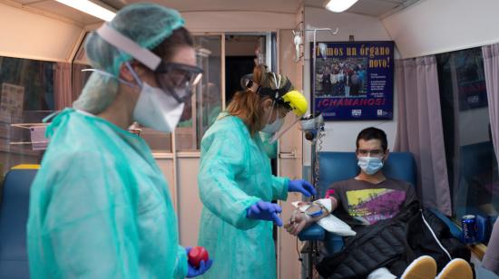 Dos médicas atienden a un paciente, mientras dona sangre en un hospital de España, el 29 d abril de 2020.