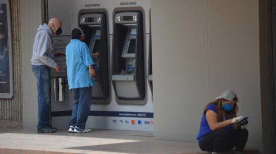 Personas tratan de sacar dinero de un cajero automático en Cuenca, el 14 de abril de 2020.
